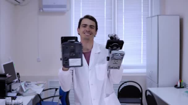 Médico feliz em um vestido médico branco dança alegremente em um laboratório de ciências médicas — Vídeo de Stock
