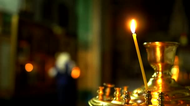 Одна свічка горить у золотому свічку Православної Церкви. — стокове відео