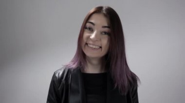 Genç bir kadının portresi. Duygularını kahkahadan şaşırmaya dönüştürüyor.