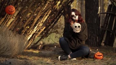 Kafatası şekeri makyajlı cadı kafatasını tutuyor ve elini etrafında gezdiriyor.