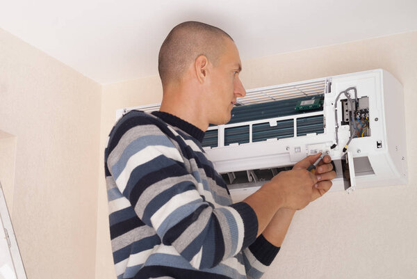 worker installs the indoor unit air conditioner on the wall
