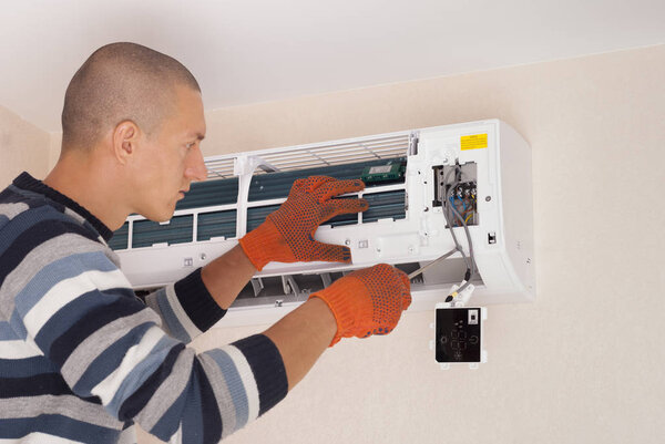 worker installs the indoor unit air conditioner on the wall