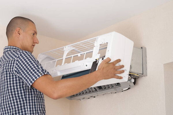 master installs indoor unit of the air conditioner