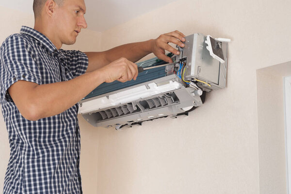worker installs the indoor unit air conditioner on the wall