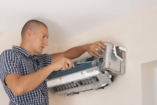 worker installs the indoor unit air conditioner on the wall