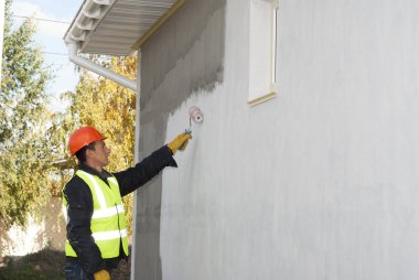 İnşaat işçisi bir rulo ile bir duvar boyama