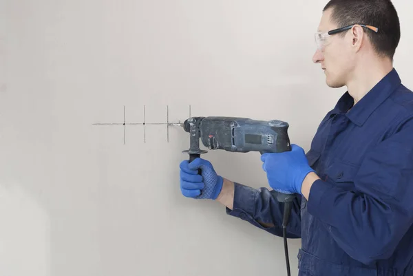 Electrician worker drills a wall — Stock Photo, Image