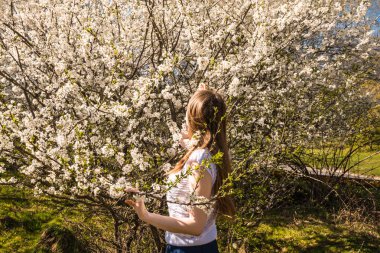 Kız bir çiçeklenme yürüyüş Bahçe bahar