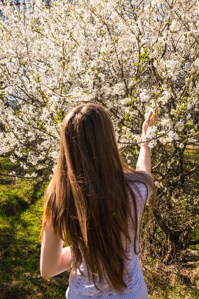 Kız bir çiçeklenme yürüyüş Bahçe bahar