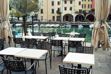 Sokakta sandalyeleri ve masaları olan kafe.