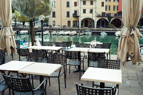 Sokakta sandalyeleri ve masaları olan kafe.