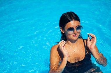 Zarif seksi kadın güneş tabaklanmış ince ve düzgün vücut üzerinde bikini Yüzme Havuzu poz