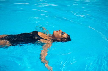 Zarif seksi kadın güneş tabaklanmış ince ve düzgün vücut üzerinde bikini Yüzme Havuzu poz