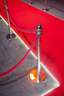 Uzun kırmızı halı ipi engelleri giriş arasında.