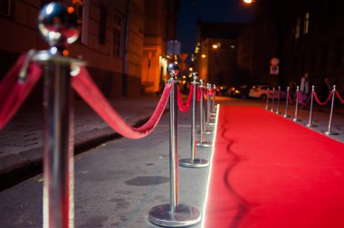 Uzun kırmızı halı ipi engelleri giriş arasında.
