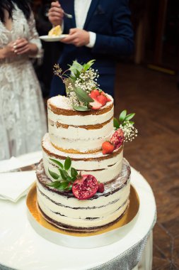 Çiçekli düğün pastası ve diğer tatlılar.