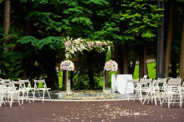 Beyaz sandalyeli ve çiçekli düğün kemeri