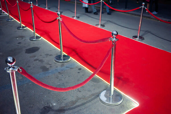 Long red carpet between rope barriers on entrance.