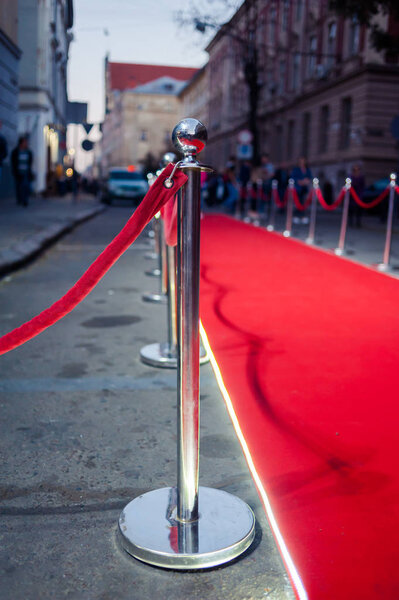 Long red carpet between rope barriers on entrance.