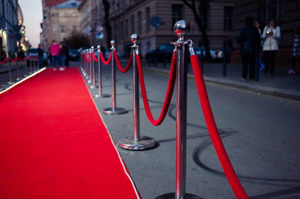 Long red carpet between rope barriers on entrance.