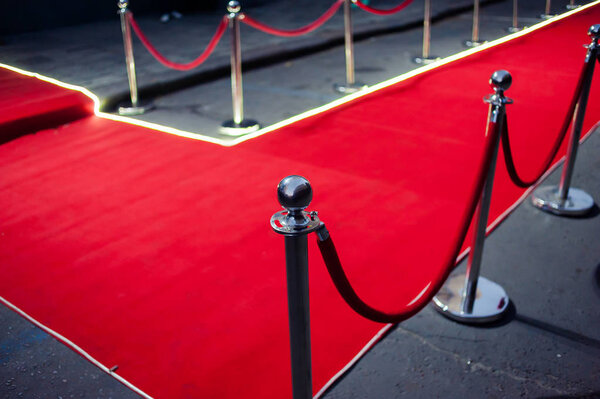 Long red carpet between rope barriers on entrance.