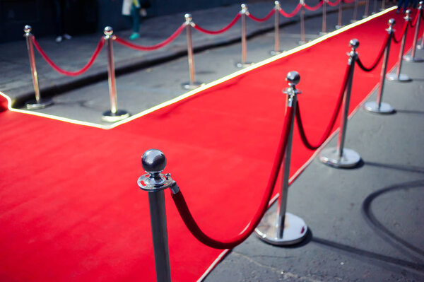 Long red carpet between rope barriers on entrance.