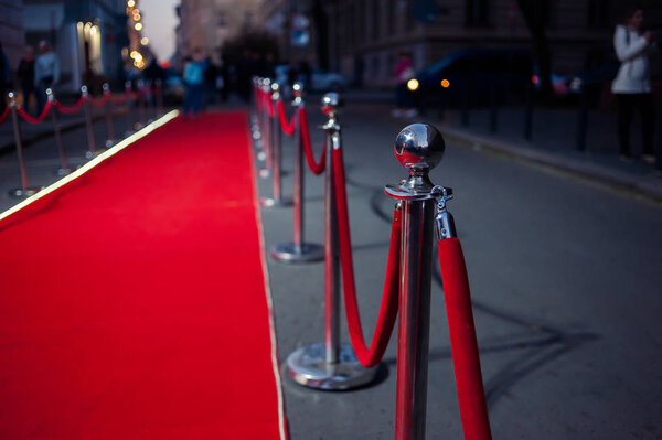 Long red carpet between rope barriers on entrance.