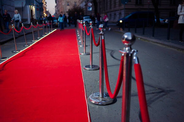 Long red carpet between rope barriers on entrance.