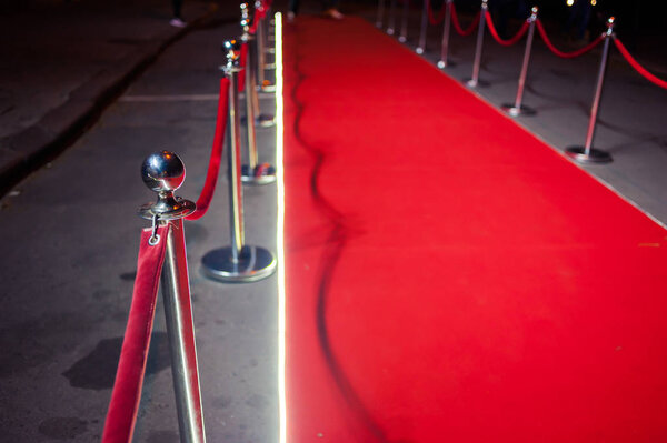 Long red carpet between rope barriers on entrance.
