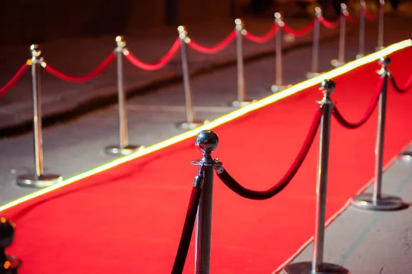 Uzun kırmızı halı ipi engelleri giriş arasında.