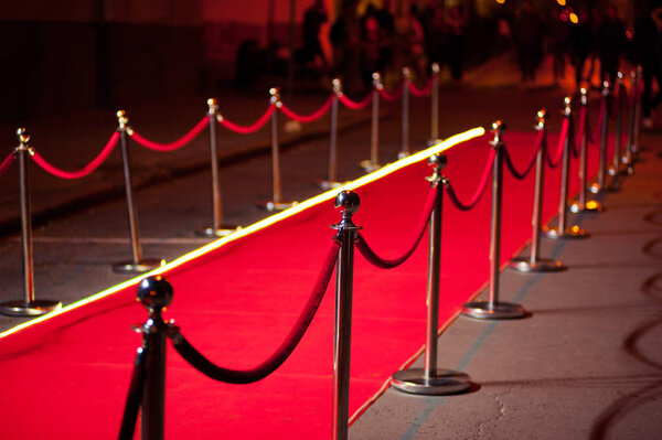 Long red carpet between rope barriers on entrance.
