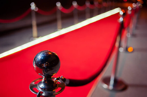 Long red carpet between rope barriers on entrance.