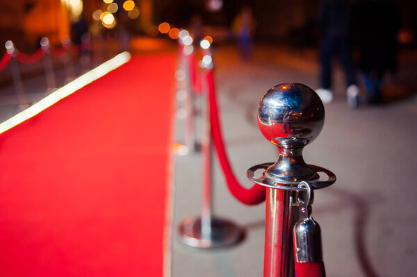Long red carpet between rope barriers on entrance.
