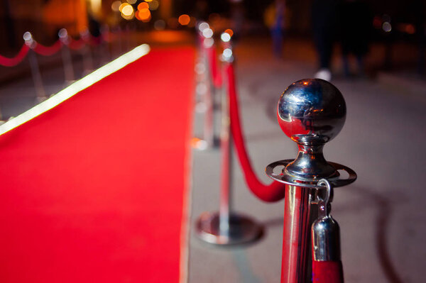 Long red carpet between rope barriers on entrance.
