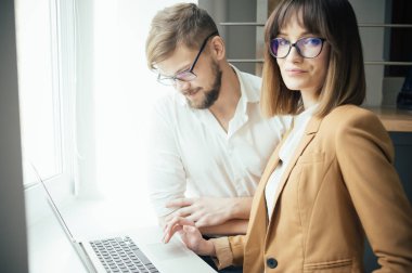 İki genç arkadaşları giyinmiş casual beyaz iç dizüstü bilgisayar kullanarak