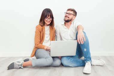 İki genç arkadaşları giyinmiş casual beyaz iç dizüstü bilgisayar kullanarak