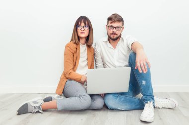 İki genç arkadaşları giyinmiş casual beyaz iç dizüstü bilgisayar kullanarak