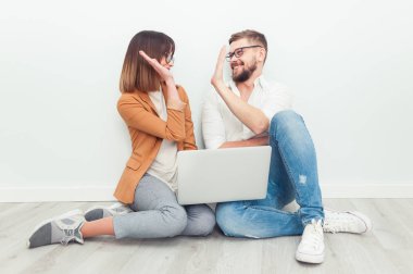 İki genç arkadaşları giyinmiş casual beyaz iç dizüstü bilgisayar kullanarak