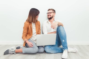 İki genç arkadaşları giyinmiş casual beyaz iç dizüstü bilgisayar kullanarak