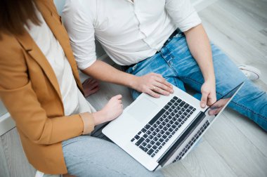 İki genç arkadaşları giyinmiş casual beyaz iç dizüstü bilgisayar kullanarak