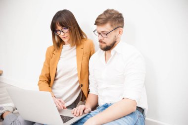 İki genç arkadaşları giyinmiş casual beyaz iç dizüstü bilgisayar kullanarak