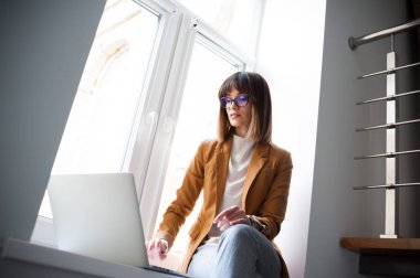 Casual giyim gözlük güzel kadın tasarımcı freelancer laptop kullanma beyaz office