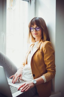 Casual giyim gözlük güzel kadın tasarımcı freelancer laptop kullanma beyaz office