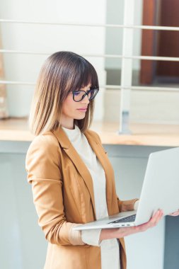 Casual giyim gözlük güzel kadın tasarımcı freelancer laptop kullanma beyaz office