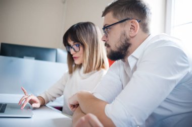 Rahat giyen iki arkadaşları ofiste dizüstü bilgisayar kullanarak.