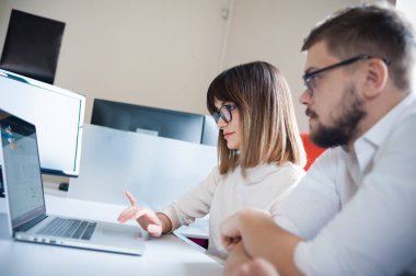 İki genç arkadaşları giyinmiş casual beyaz iç dizüstü bilgisayar kullanarak