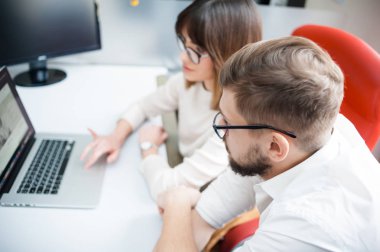 Rahat giyen iki arkadaşları ofiste dizüstü bilgisayar kullanarak.