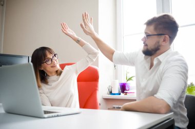 Rahat giyen iki arkadaşları ofiste dizüstü bilgisayar kullanarak.