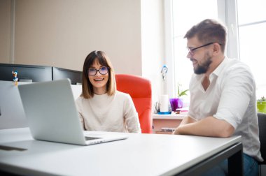 İki genç arkadaşları giyinmiş casual beyaz iç dizüstü bilgisayar kullanarak