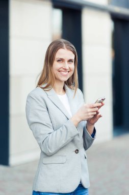 Güzel genç işkadını Smartphone kullanarak